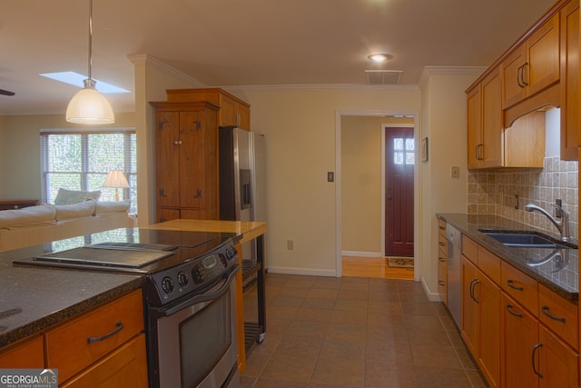 kitchen with appliances with stainless steel finishes, a sink, decorative backsplash, and ornamental molding