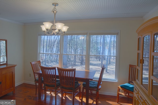 dining room featuring baseboards, ornamental molding, wood finished floors, and an inviting chandelier