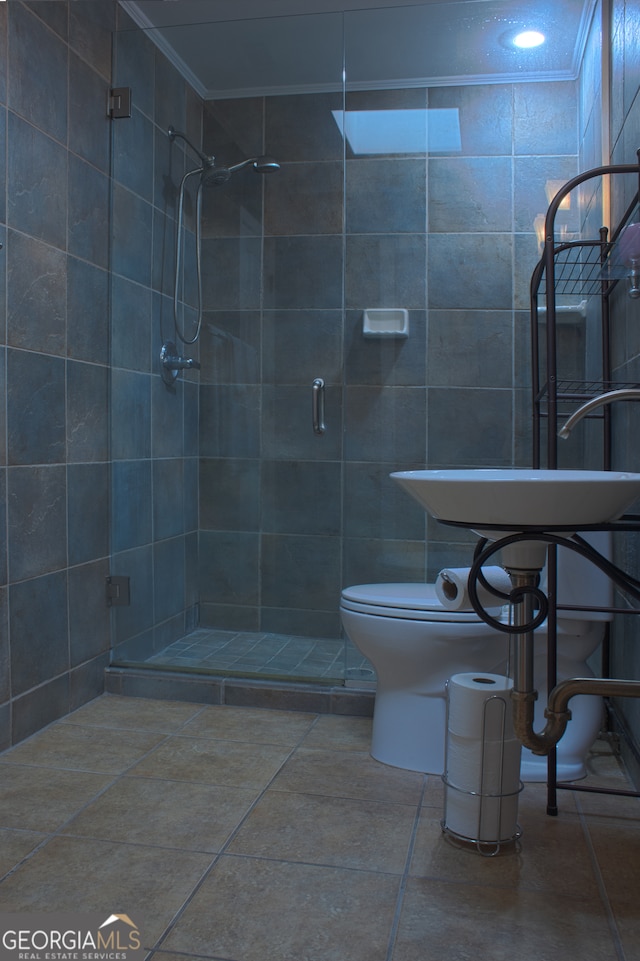 bathroom with tile walls, crown molding, a shower stall, and toilet