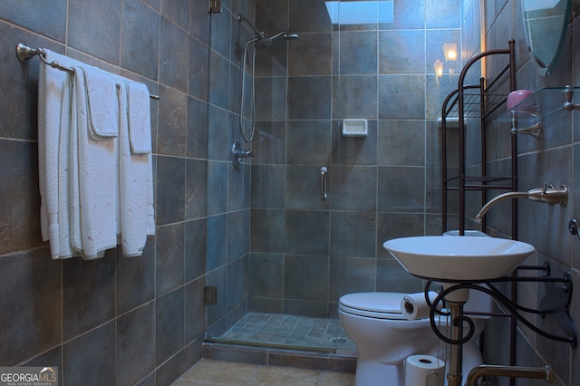 bathroom with tile patterned flooring, a sink, a shower stall, and toilet