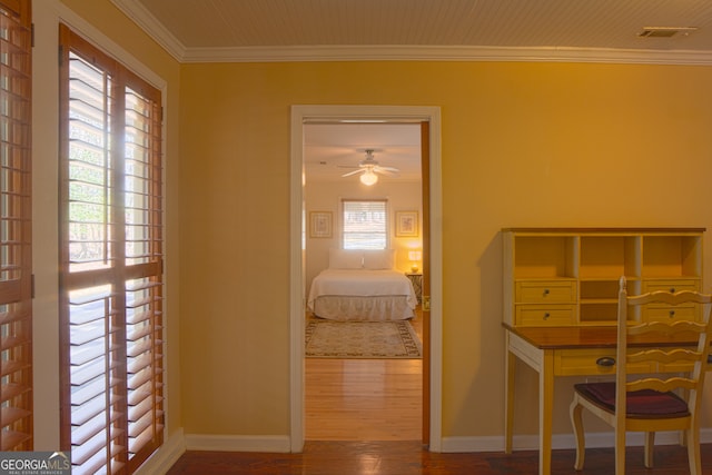 bedroom featuring baseboards, wood finished floors, visible vents, and crown molding