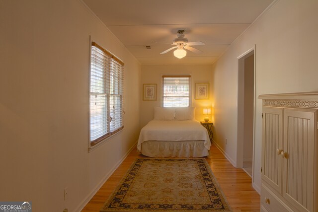 bedroom featuring crown molding, hardwood / wood-style flooring, and ceiling fan