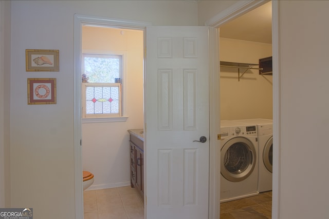 laundry area with laundry area, light tile patterned floors, baseboards, ornamental molding, and independent washer and dryer