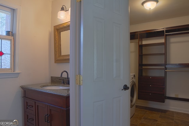 bathroom with washer / dryer, plenty of natural light, and vanity