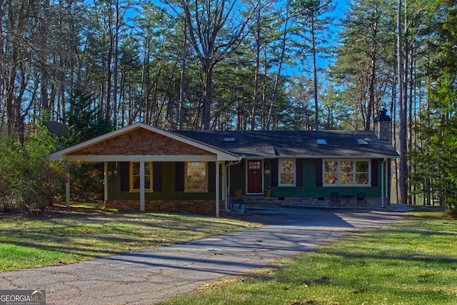 ranch-style house featuring aphalt driveway, a chimney, and a front yard