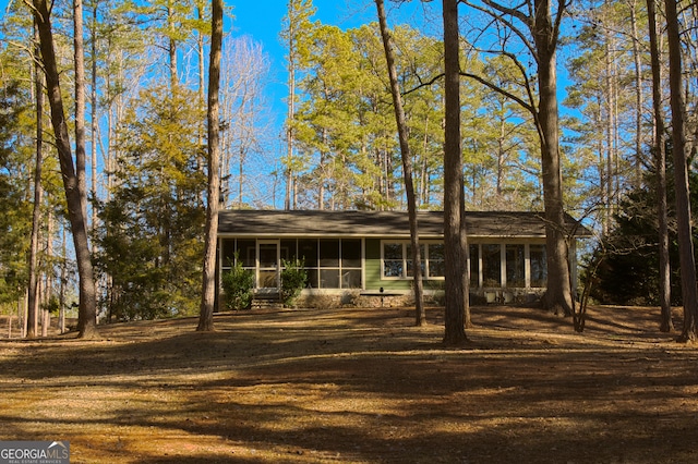 view of front of property with a front yard and a sunroom