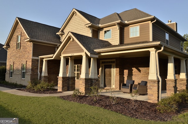 craftsman inspired home with a porch and a front lawn