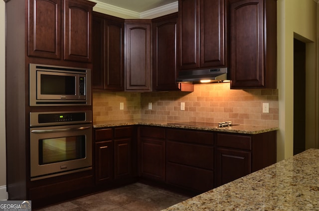 kitchen with appliances with stainless steel finishes, light stone counters, and tasteful backsplash