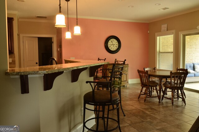 interior space featuring pendant lighting, tile patterned floors, and ornamental molding