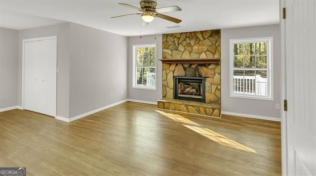 unfurnished living room featuring a fireplace, hardwood / wood-style flooring, plenty of natural light, and ceiling fan