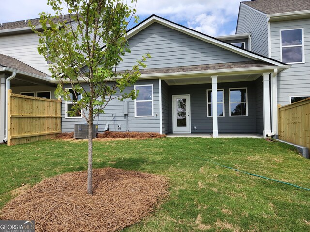 view of front of property with central air condition unit and a front lawn