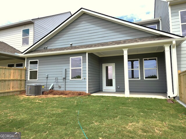 back of property with cooling unit and a lawn