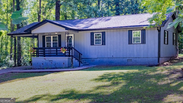 view of front of house with crawl space, covered porch, a front lawn, and roof with shingles