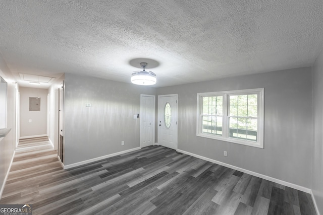 entrance foyer with dark wood-style floors, a textured ceiling, and baseboards