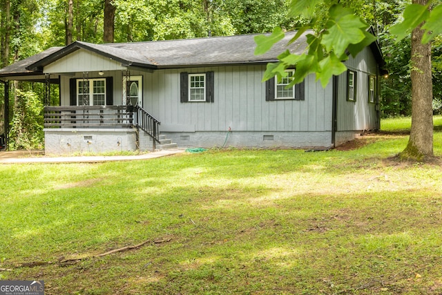 view of front of home with a shingled roof, crawl space, covered porch, and a front lawn