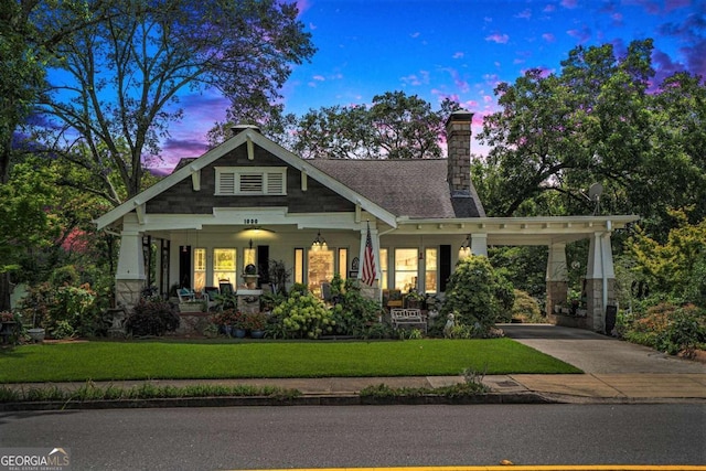 craftsman inspired home featuring a yard, a carport, and covered porch