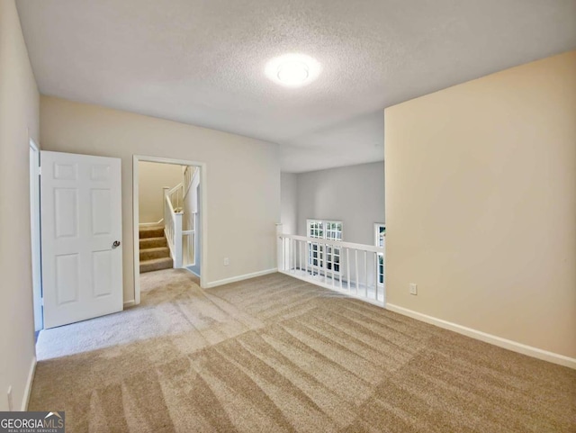 carpeted spare room featuring a textured ceiling