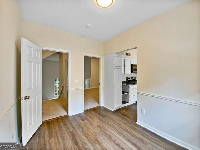 empty room with wood-type flooring and a textured ceiling