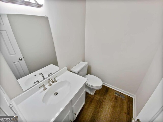 bathroom featuring hardwood / wood-style flooring, vanity, and toilet