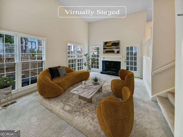 living room featuring light carpet and a high ceiling