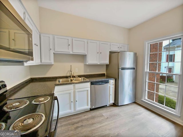 kitchen with white cabinetry, sink, stainless steel appliances, and light wood-type flooring