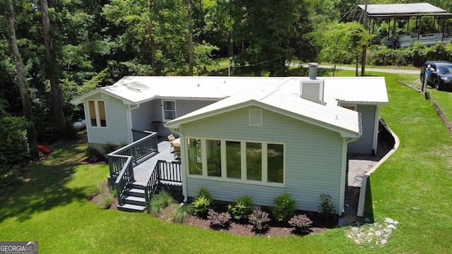 rear view of property featuring a wooden deck and a yard