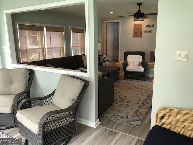 living area featuring hardwood / wood-style flooring, ornamental molding, and plenty of natural light