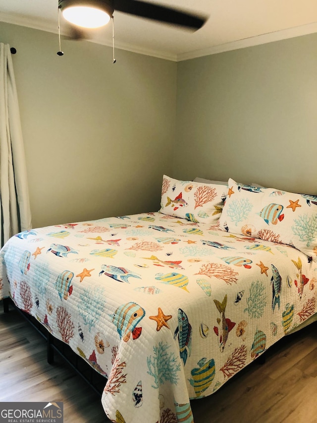 bedroom featuring hardwood / wood-style flooring, ceiling fan, and ornamental molding