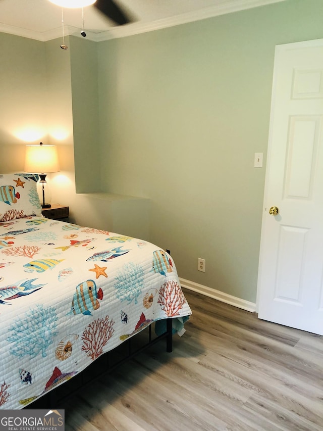 bedroom with crown molding, ceiling fan, and hardwood / wood-style floors