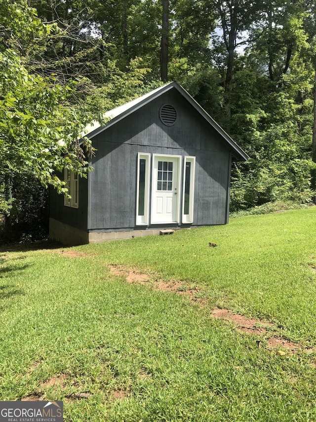 view of outbuilding featuring a lawn