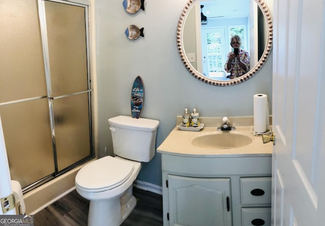 bathroom featuring walk in shower, toilet, vanity, hardwood / wood-style flooring, and ceiling fan