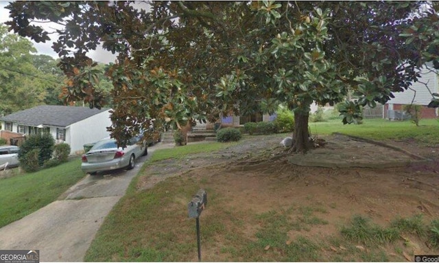 view of property hidden behind natural elements featuring a front yard