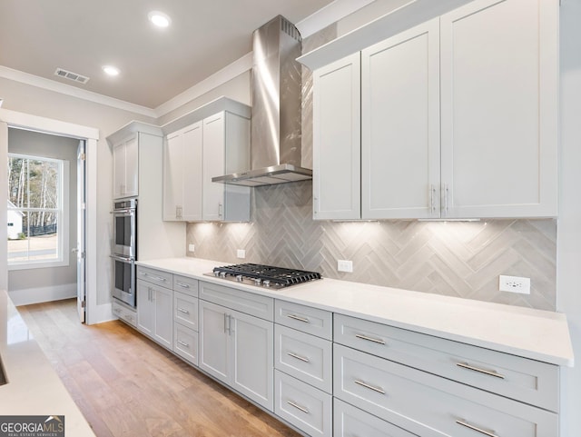 216 Ewing Way, Dacula, GA 30019 - kitchen with wall chimney range hood, appliances with stainless steel finishes, backsplash, light countertops, and ornamental molding