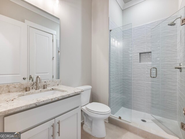 bathroom with tile patterned flooring, vanity, an enclosed shower, and toilet