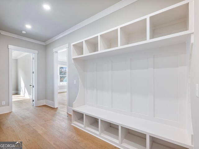 mudroom featuring wood-type flooring and ornamental molding