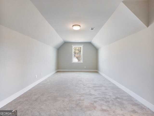 additional living space with light colored carpet and lofted ceiling