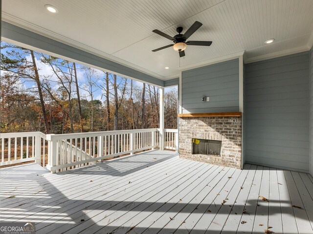 wooden terrace with ceiling fan and an outdoor brick fireplace