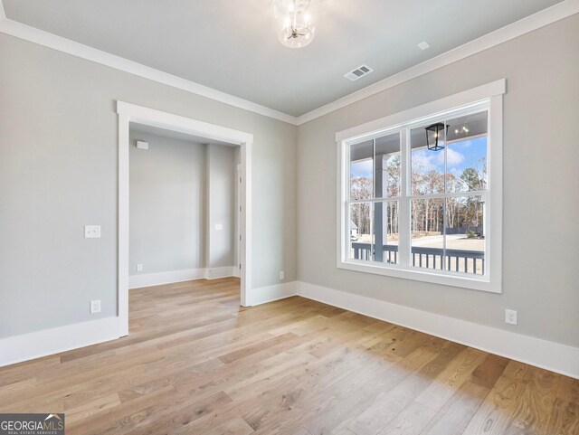 empty room with crown molding and light wood-type flooring