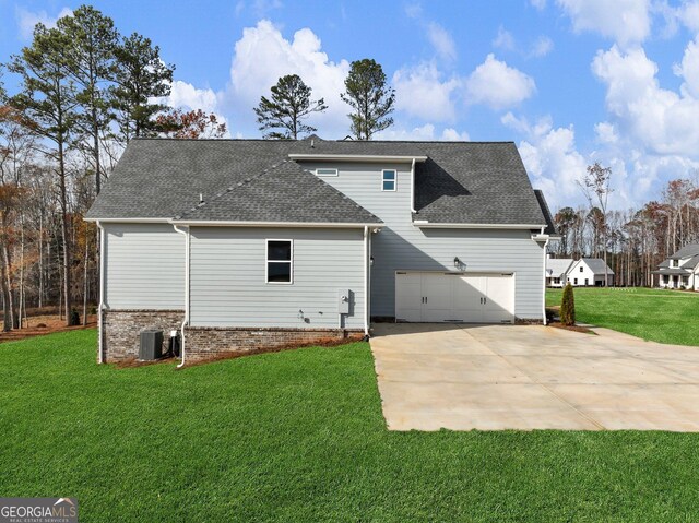 rear view of property featuring a lawn and central AC