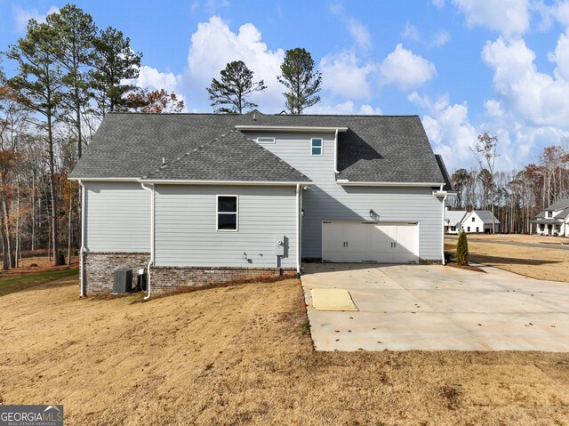 rear view of house with a garage and cooling unit