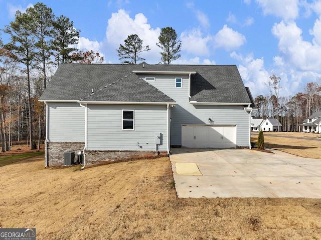 216 Ewing Way, Dacula, GA 30019 - rear view of property with a shingled roof, driveway, and a garage