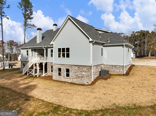 back of property featuring central AC unit and a lawn