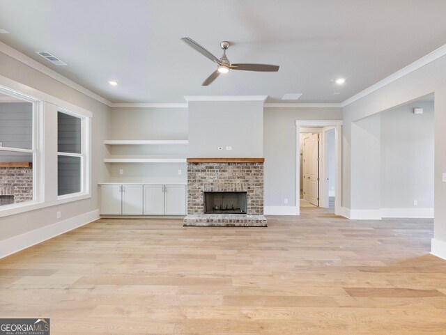 unfurnished living room with crown molding, ceiling fan, light hardwood / wood-style floors, and a brick fireplace