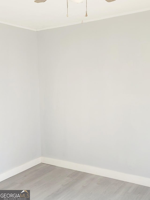 spare room featuring hardwood / wood-style floors, ceiling fan, and ornamental molding