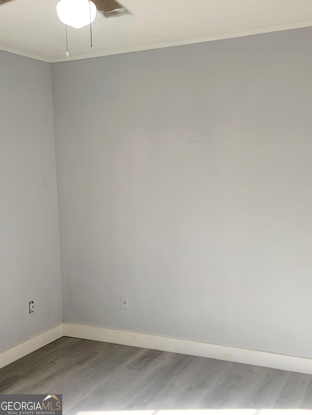 unfurnished room featuring hardwood / wood-style flooring and crown molding