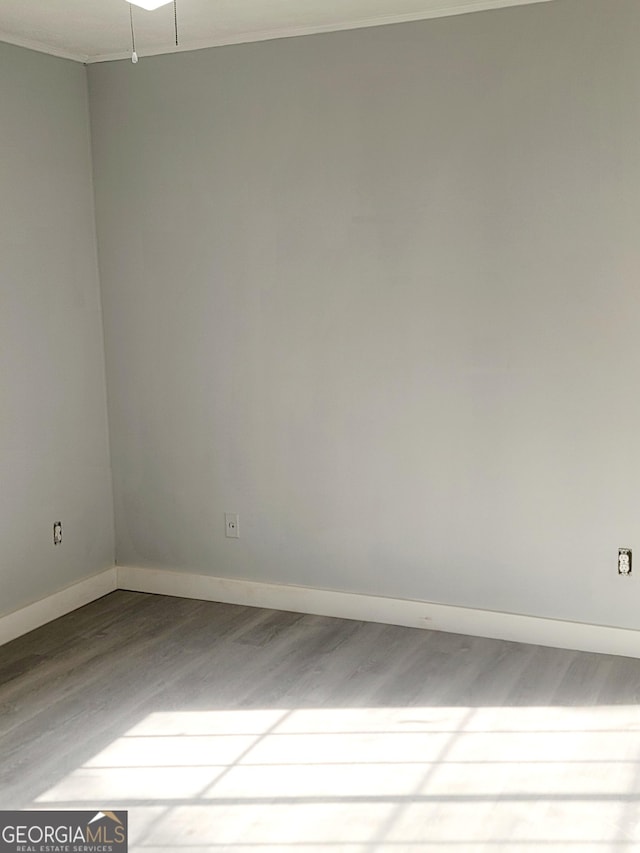 unfurnished room featuring ornamental molding and hardwood / wood-style flooring