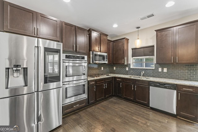 kitchen with decorative backsplash, stainless steel appliances, dark hardwood / wood-style flooring, and hanging light fixtures