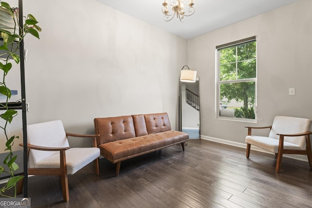 sitting room with dark wood-type flooring and a chandelier