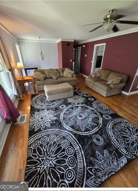 living room with ornamental molding, hardwood / wood-style floors, and ceiling fan