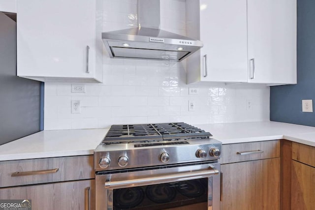 kitchen featuring white cabinets, backsplash, and stainless steel range